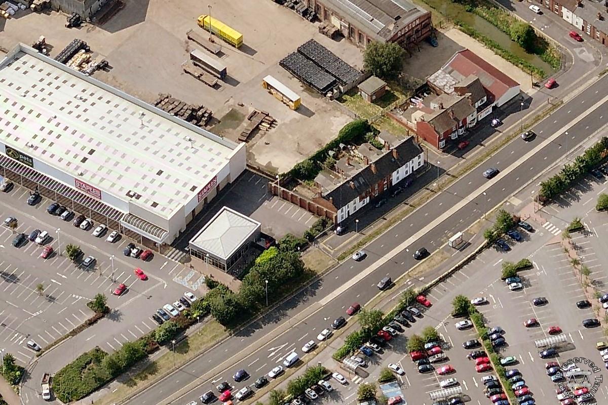 Foster works on Waterloo Street - the tall, buttressed brick wall in the centre of picture is all that remains of the factory (a remaining building from the neighbouring Ruston works can be seen in the background)