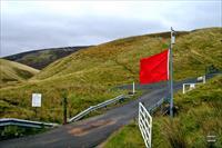 The road leading into the Ministry Of Defence Ranges, and the red flag showing that the army are practising live firing there today, photo and caption by SarahD