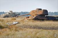 “A Wolfhound armoured vehicle manoeuvres around the rusting carcass of a tank at the Crew Training School on Sennelager Training Area, northern Germany [Picture: Sergeant Mark Nesbit, Crown Copyright/MOD 2010]”